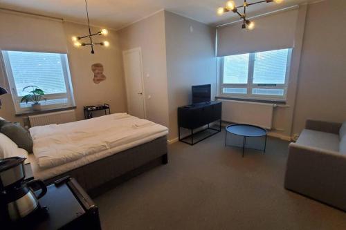 een slaapkamer met een bed, een bank en een tafel bij Hangon Asema 3 - Vastaremontoitu yksiö kylpyhuoneella in Hanko