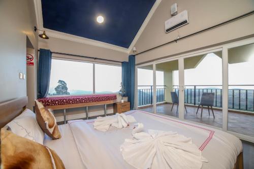 a bedroom with a large bed and a balcony at Eagles Wings Abode in Coonoor