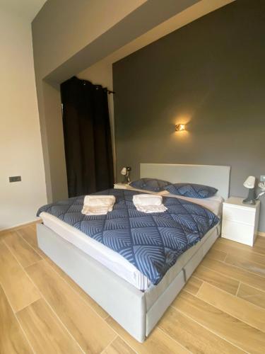 1 dormitorio con 1 cama grande con edredón azul en Rooms Matić 2 en Velika Mlaka
