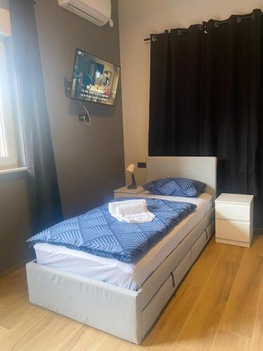 a bedroom with a bed with a blue comforter at Rooms Matić 2 in Velika Mlaka