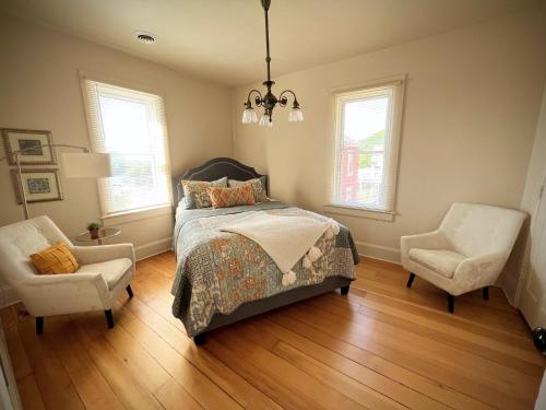 a bedroom with a bed and two chairs at Bluffside cottage with gorgeous river views in Fountain City