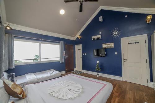 a bedroom with a large bed with a blue wall at Eagles Wings Abode in Coonoor