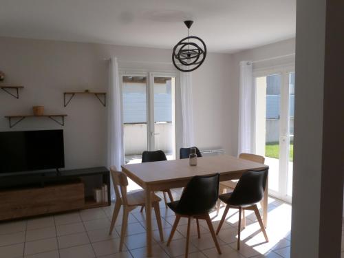 une salle à manger avec une table, des chaises et une télévision dans l'établissement Charmante maison rénovée avec terrasse, proche mer, La Tranche-sur-Mer, 6 pers, Wifi, parking. - FR-1-194-224, à La Tranche-sur-Mer