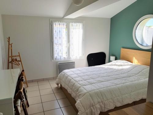 une chambre avec un lit et une fenêtre dans l'établissement Charmante maison rénovée avec terrasse, proche mer, La Tranche-sur-Mer, 6 pers, Wifi, parking. - FR-1-194-224, à La Tranche-sur-Mer