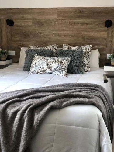 a large white bed with a blanket on it at Aromos Lodge- Chacras de Coria- in Ciudad Lujan de Cuyo