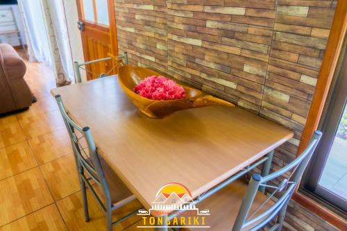 a table with a bowl of pink flowers on it at Cabaña Tongariki in Hanga Roa