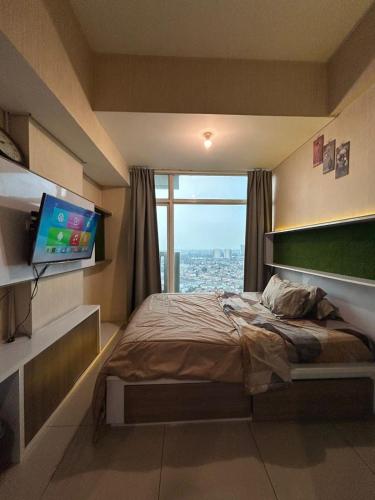 1 dormitorio con cama y ventana grande en QnM Rooms at Treepark City, en Tjikokol