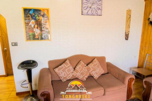 a living room with a couch with pillows on it at Cabaña Tongariki in Hanga Roa