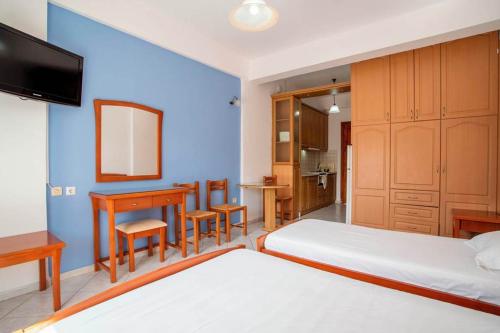 1 dormitorio con 2 camas, mesa y escritorio en Kallisti, en Finikounta