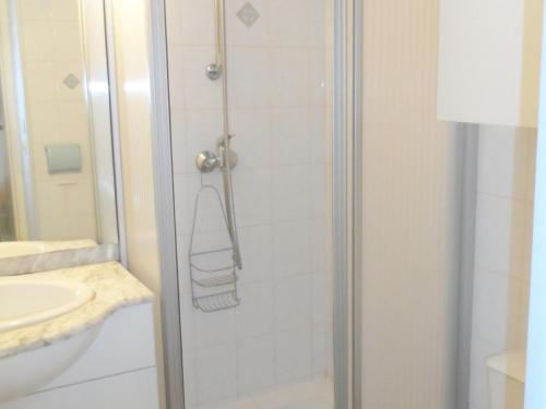 La salle de bains est pourvue d'une douche et d'une serviette. dans l'établissement Grand studio en hyper-centre de Cabourg avec balcon, proche plage, parking, et prestations disponibles - FR-1-487-327, à Cabourg