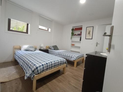 a bedroom with two beds and a sink in it at Casa da Rosa in Arcozelo