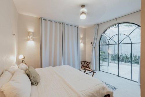 um quarto com uma cama grande e uma janela grande em Casa La Sultana: Amazing new house with pool em Valladolid
