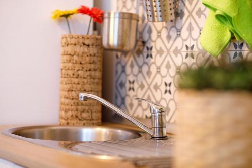 - un évier de cuisine avec un robinet et un vase dans l'établissement Italica Hostel, à Santiponce
