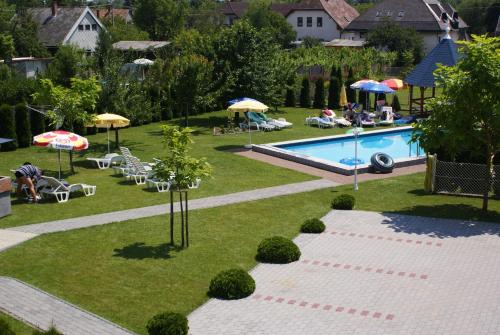 an overhead view of a swimming pool with umbrellas and chairs at Kék Vendégház Family Resort in Gyenesdiás