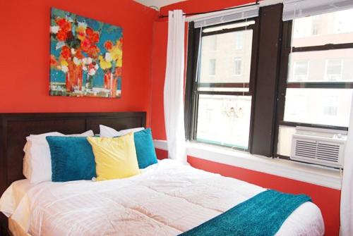 a bedroom with red walls and a bed with colorful pillows at Relaxing 3 BR near Times Square in New York