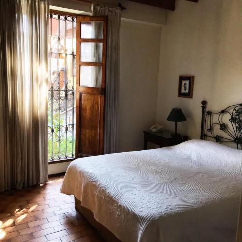 a bedroom with a bed and a large window at Hotel & Hacienda El Carmelo in Ica