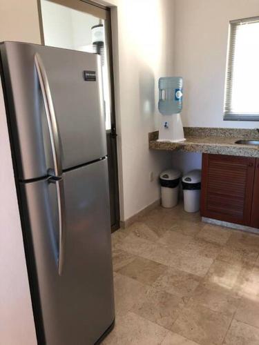 a kitchen with a stainless steel refrigerator in a kitchen at Villa Talia, Relax, beach & Nature in Puerto Aventuras