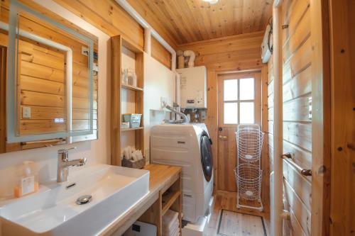 a bathroom with a sink and a refrigerator at The Lodge 弟子屈 in Teshikaga