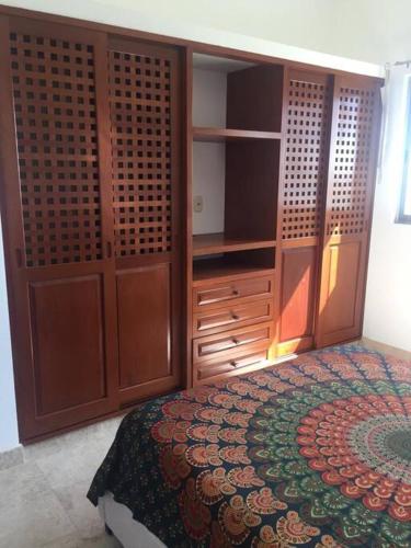 a bedroom with a bed and wooden cabinets at Villa Talia, Relax, beach & Nature in Puerto Aventuras