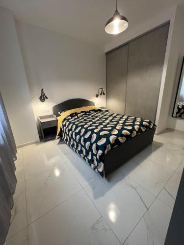 a bedroom with a bed and a white tiled floor at Appartement Marseille - Le Canet in Marseille