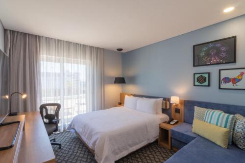 Habitación de hotel con cama y sofá en Hampton by Hilton Aguascalientes Downtown en Aguascalientes