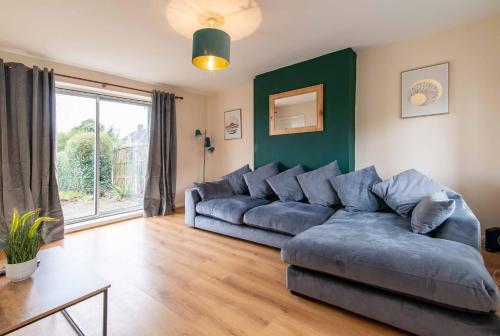 a living room with a blue couch and a green wall at Your Nottingham Haven - 3 Bed House with Free Wifi and Parking in Nottingham