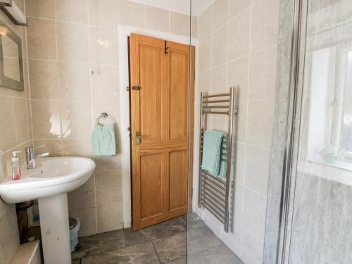 baño con lavabo, aseo y puerta en Spring Cottage, en Duns