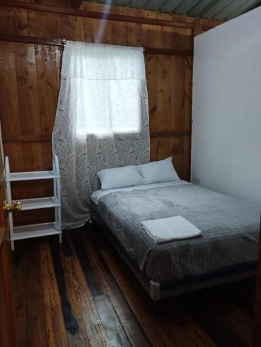 MINDO SUM في ميندو: سرير في غرفة خشبية مع نافذة