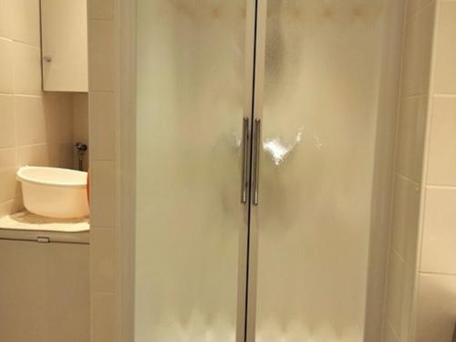 une douche avec une porte vitrée dans une salle de bain dans l'établissement Appartement Type 2 avec balcon et parking - Les Sables-d'Olonne - FR-1-331-216, à Les Sables-dʼOlonne