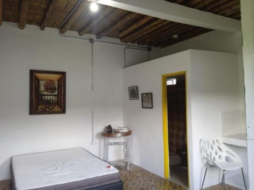 Zimmer mit einem Bett, einem Tisch und einem Stuhl in der Unterkunft Santa Irene de Palomino - Sevilla Valle del Cauca in Sevilla
