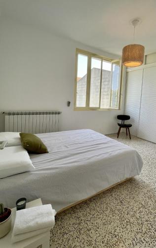 a white bedroom with a large bed in a room at Chambre au calme en cœur de ville in Cavaillon
