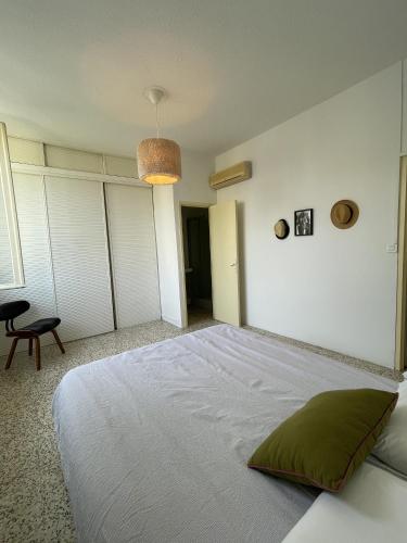 - une chambre avec un grand lit blanc et un oreiller vert dans l'établissement Chambre au calme en cœur de ville, à Cavaillon