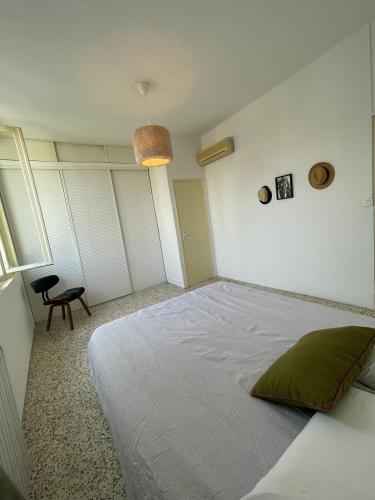 a bedroom with a large white bed with a green pillow at Chambre au calme en cœur de ville in Cavaillon