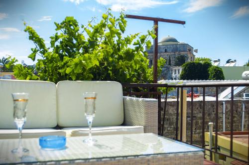 a table with two wine glasses on a balcony at Petrino in Rhodes Town
