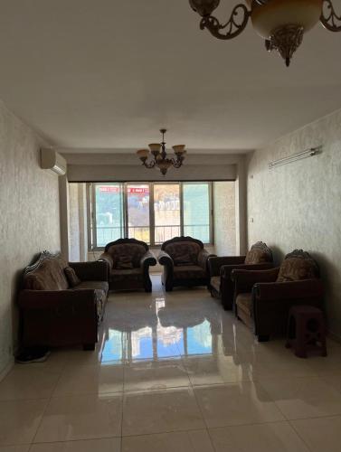 duży salon z kanapami i żyrandolem w obiekcie Salah Khamlan Apartments w mieście Nablus