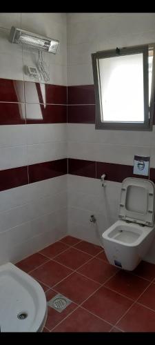 a bathroom with a toilet and a window at Salah Khamlan Apartments in Nablus