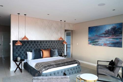 a bedroom with a large bed and a couch at Luxury Zimbali Villa*7 Grandview*Seaview*Pool* in Ballito