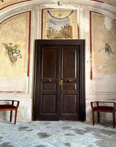 una puerta de madera en una habitación con pinturas en las paredes en LA CASA DEL MOSAICO, en Angri