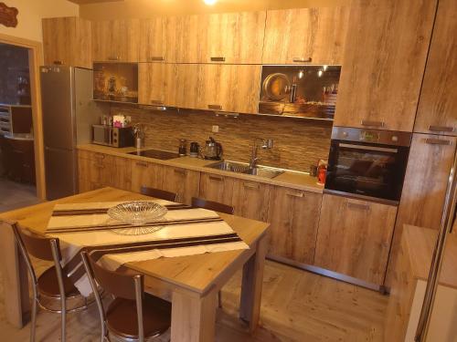- une cuisine avec des placards en bois, une table et un évier dans l'établissement Villa Stella, à Flórina