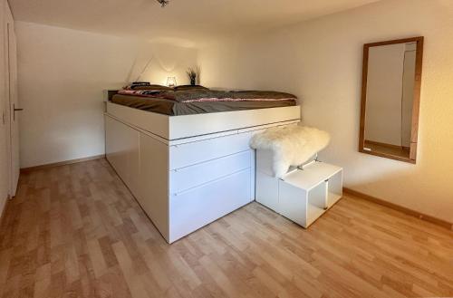 a bedroom with a bed with a dresser and a mirror at Chalet Ribi in Grindelwald