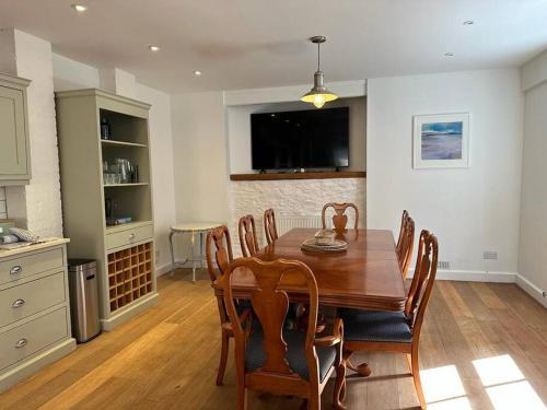 a dining room with a wooden table and chairs at Home in Dartmouth, Devon with Private Parking in Dartmouth