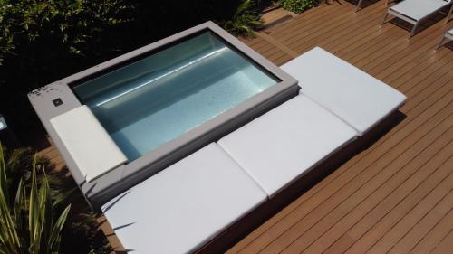 a bench on a deck with a table at Hotel Villa Alberta in Nago-Torbole