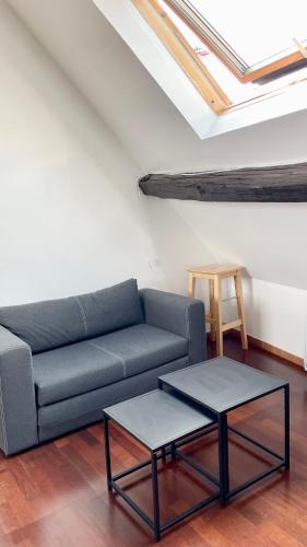 un salon avec un canapé et deux tables dans l'établissement Le P'tit Villiers - Charmant logement proche Paris, à Villiers-sur-Marne