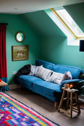 Sofá azul en la sala de estar con ventana en The Hayloft en Banchory
