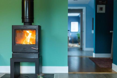 a wood stove in a room with a hallway at The Hayloft in Banchory
