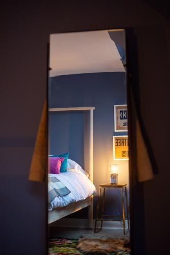 1 dormitorio con cama y espejo en una habitación en The Hayloft en Banchory