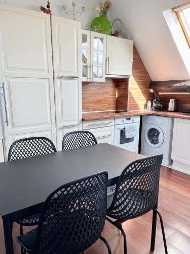 une cuisine avec une table et des chaises noires dans l'établissement Le P'tit Villiers - Charmant logement proche Paris, à Villiers-sur-Marne
