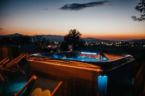 a bath tub on a deck with the sunset in the background at Górskie Tarasy in Rabka-Zdrój