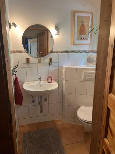 ein Badezimmer mit einem Waschbecken, einem WC und einem Spiegel in der Unterkunft Ferienwohnung am Venn in Monschau