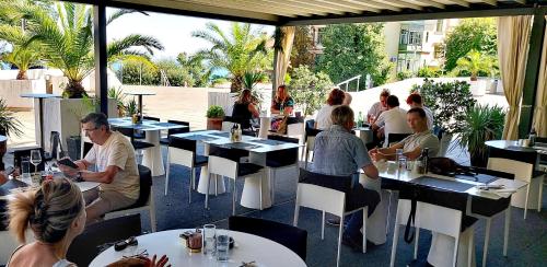 un grupo de personas sentadas en mesas en un restaurante en The routes of Habsburg (beach 70 m) en Opatija